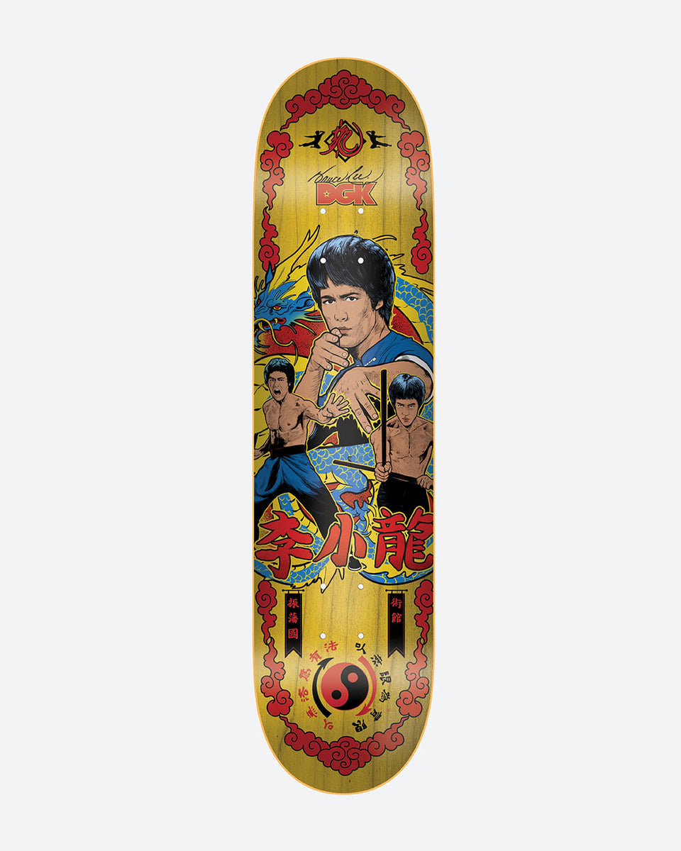 DGK x Bruce Lee Fury skateboard deck: Yellow wood-grain deck with a red cloud-pattern border, showing an illustrated martial artist in three poses, one holding nunchaku, in front of a blue dragon. Red Chinese characters, a yin-yang symbol and a DGK logo with signature complete it.