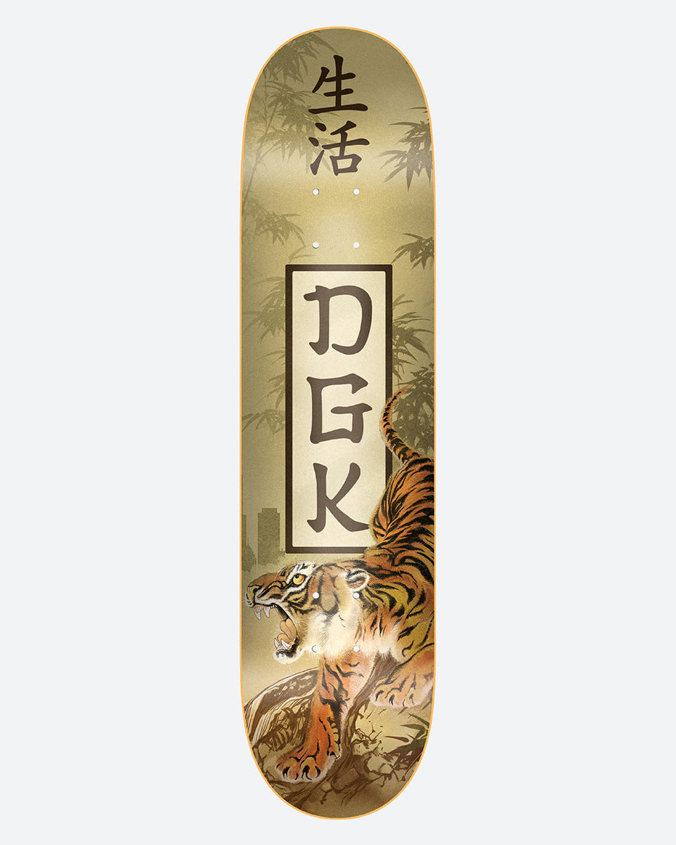 DGK Protector skateboard deck: Painted snarling tiger climbing a rock in front of bamboo and a faint city skyline, on a gold-beige background. A boxed DGK logo in Japanese-style lettering sits in the middle with kanji above.