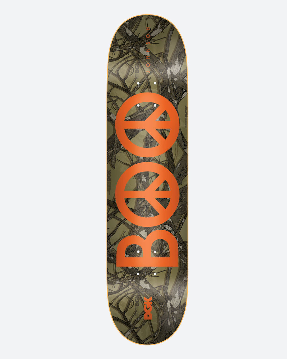 DGK Woodland Boo 8.25 skateboard deck: A large orange peace-sign pair forming the letters BOO over a woodland camouflage pattern of twigs and branches in olive and grey. Small DGK logo near the tail.