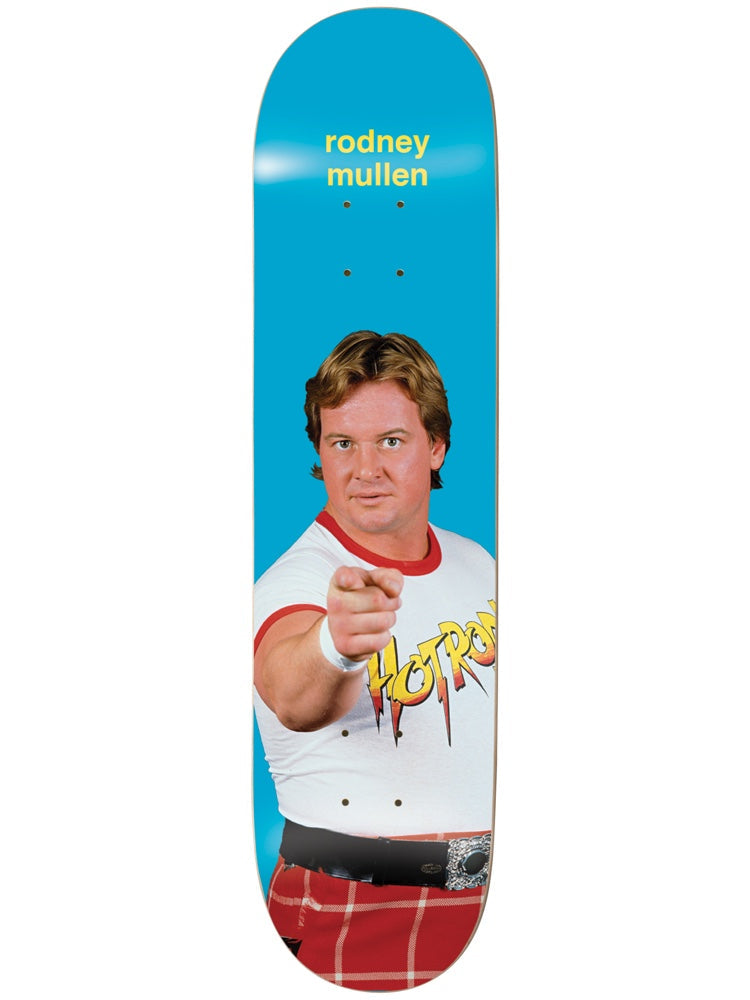 Enjoi Mullen Round 3 R7 8.0 & 8.25 skateboard deck: Photograph of a smiling man with feathered hair pointing at the viewer, wearing a white shirt with red collar and printed Hot Rod lettering and a red tartan kilt, on a blue deck. Rider name in yellow at the top.