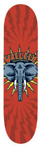 Vallely Elephant Icon skateboard deck: Blue-grey elephant head with white tusks inside a yellow starburst, under curved Vallely Skateboards lettering, on a red background with darker lightning bolts radiating out.
