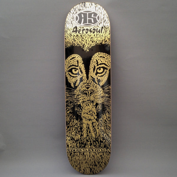 Insane Insane x Aerosoul Peaceful Lion skateboard deck: Gold line-drawn lion's face on black with intense eyes, making a peace sign with a hand held at its mouth, within a fur-like texture. The Aerosoul logo is at the top and Insane at the bottom.