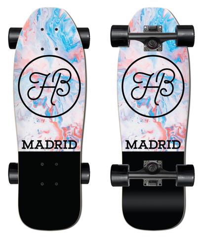 Madrid Stub Nose 25 skateboard deck: A small cruiser shown from top and underside, with a pastel marbled swirl of pink, blue and white, a black circle containing a looped HB monogram, and Madrid lettering above a solid black tail.