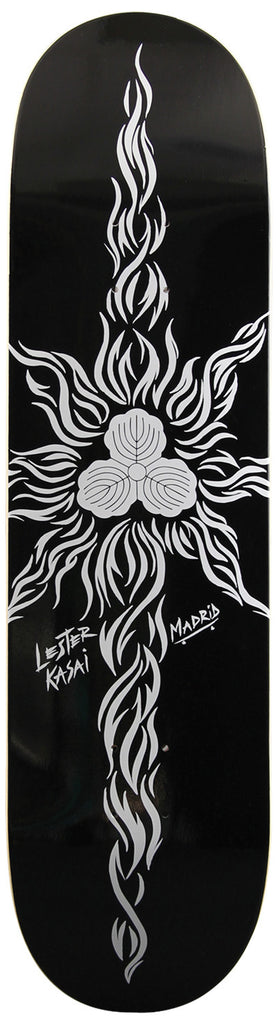 Madrid Lester Kasai 8 skateboard deck: Silver-white tribal-style flame design radiating from a central three-lobed emblem like a stylised sun on a black deck, with the rider's name handwritten and a Madrid logo to the side.