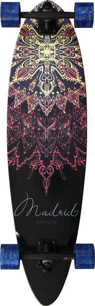 Madrid Blunt 36.25 skateboard deck: Pintail longboard with a symmetrical mandala of fine ornate linework in yellow fading to pink and red on black, with the brand name in thin script and 'Made in USA' beneath. Shown as a complete with trucks and blue wheels.
