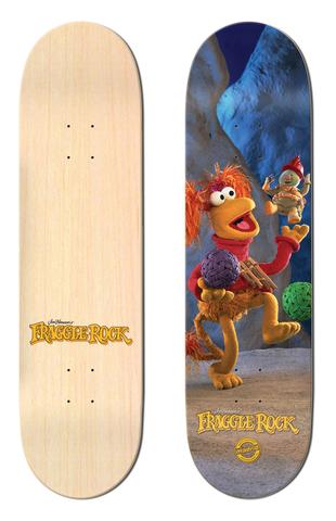 Madrid x Fraggle Rock Red 8 skateboard deck: A photographic image of Red Fraggle from Fraggle Rock juggling balls in a blue cave while a small Fraggle leaps overhead. Plain natural-wood deck shown beside it, with the Fraggle Rock logo at the tail.