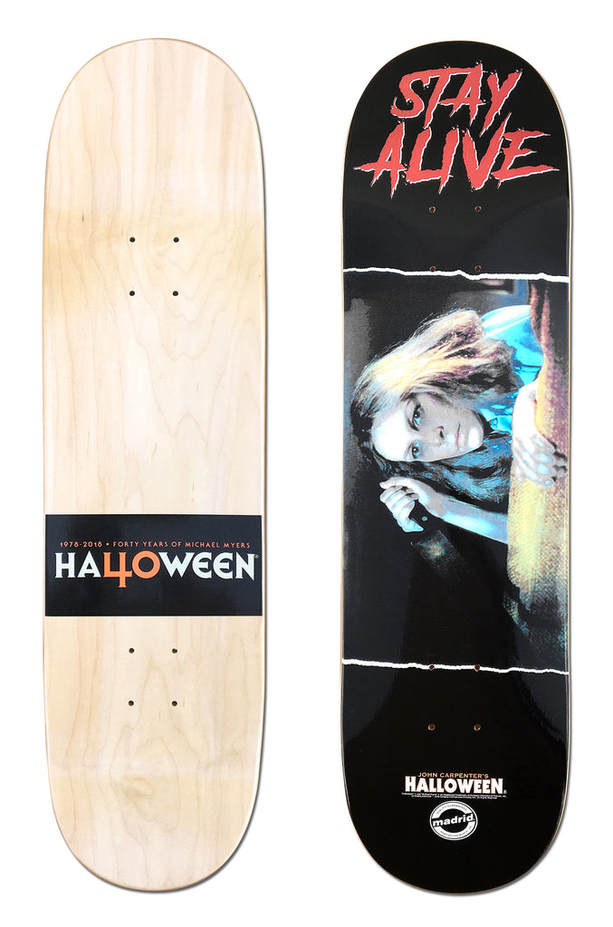 Madrid X Halloween - Laurie 8 skateboard deck: Black deck with red dripping 'STAY ALIVE' lettering above a film still of a frightened woman hiding by a wall, with a Halloween film logo. The underside has a black Halloween 40 years banner on natural wood.
