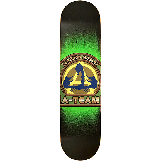 A-Team Gershon Mosley Crest skateboard deck: Military-style round crest in olive, brown and yellow with a blue stylised A emblem, ringed by the rider name above and A-Team below. A bright green spray fade glows behind it on a black deck.
