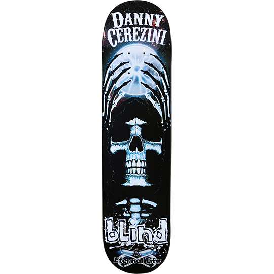 Blind Danny Cerezini Cross Light skateboard deck: Black deck with a glowing blue-white skull formed into a cross, with skeletal ribs arching above it against a hazy moon and starry sky. Rider name in white at the top and Blind logo with Eternal Life tag at the tail.