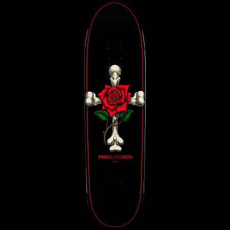Powell Peralta Funshape Rose Cross skateboard deck: A red rose with green leaves and a thorny stem sits at the centre of a cross made of bones, on a black deck with a thin red outline. Powell Peralta name in red below.