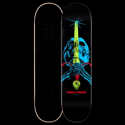 Powell Peralta BL Skull & Sword 2 - Blacklight skateboard deck: Blue skull with a yellow-green sword driven down through it, a starburst at the tip and blue skeletal hands gripping a red hilt, on a black deck. Red Powell Peralta text below; plain black underside shown beside it.