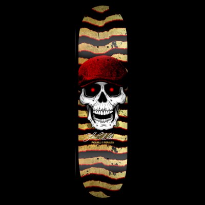 Powell Peralta Caballero Hooligan - Black/Gold skateboard deck: White skull with glowing red eyes wearing a red flat cap, over ripped zigzag stripes in gold and black edged with red. Signature and Powell Peralta text below.
