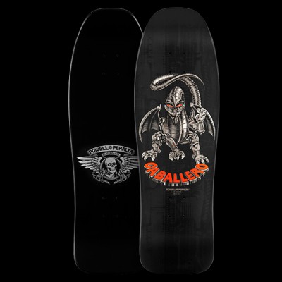 Powell Peralta Caballero Mechanical Dragon - Black skateboard deck: A silver mechanical robot dragon with red eyes and bat wings crouches on a black deck, with the name in orange 3D lettering beneath it. The underside shows a winged skull logo.