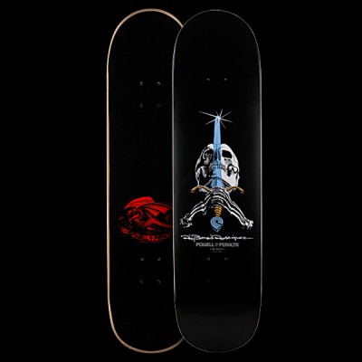 Powell Peralta Rodriguez Now - Black skateboard deck: Skull with a blue sword driven down through it and skeletal hands gripping the hilt, with a sparkle at the tip, on a black deck. White signature and Powell Peralta text below; the underside has a red dragon. Both sides shown.