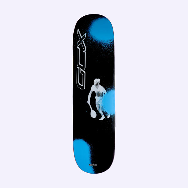 Quasi Crockett Duece skateboard deck: Silhouetted white figure of a tennis player holding a racket, with sprayed blue spots on a black deck. Outlined vertical lettering runs along the left edge and a small Quasi tag sits at the tail.