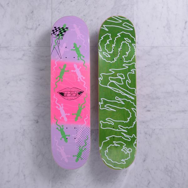 Quasi Lot Lizard Purple skateboard deck: Two decks shown. One has a lilac and pink graphic of green and pale lizards around a drawn mouth with teeth, with a chequered flag at the top. The other is green with a white wobbly outline lettering design.