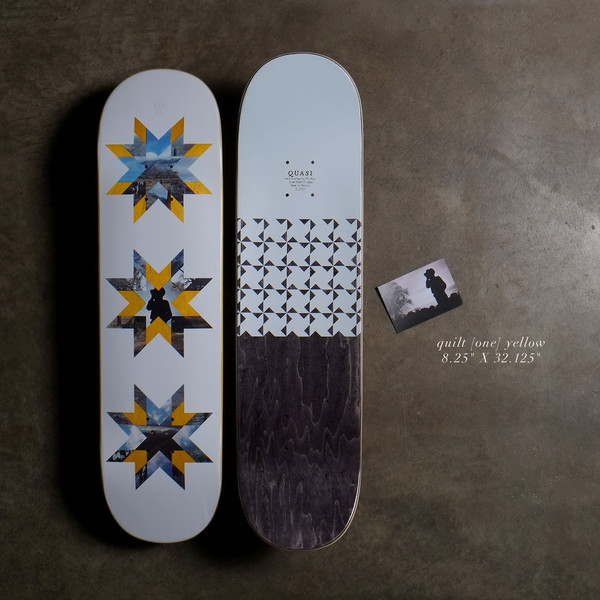Quasi Quilt - Yellow skateboard deck: Three star-shaped quilt patterns made from landscape photographs and yellow segments, on a pale blue deck. A second deck shows triangle patterns and a dark stained lower half, with a small photo card.