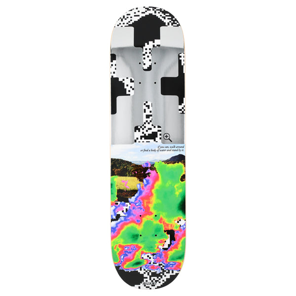 Quasi Zoom Out skateboard deck: Top half is a pixelated black-and-white cross or QR-like pattern over a grey metallic image with a magnifier icon; below, a landscape photo of hills merges into a thermal-imaging style blob in green, pink and purple. Small italic caption between.