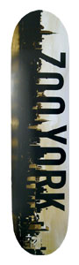 Zoo York Reflection skateboard deck: A dark New York skyline silhouette runs down the left of a cream deck, with ZOO YORK in large black capitals reading down its length. The sky has a sepia, smoky tone.