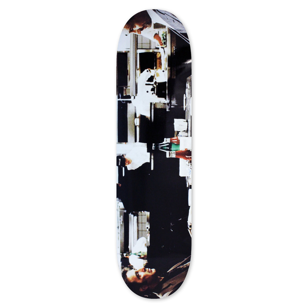 Skateboard Cafe Diner skateboard deck: Rotated film-still style photograph of a diner scene with men in suits and a waiter in a white apron, with a counter and bottles in the middle, in high-contrast colour across the whole deck.