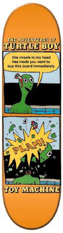 Toy Machine Turtle Boy skateboard deck: Orange deck laid out as a two-panel comic strip: a green turtle with a missile in its head speaks in a bubble, then a yellow 'PLAM!' explosion below. Title at the top and brand name at the bottom.