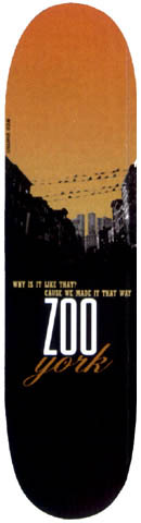 Zoo York Zoo York Cityscape skateboard deck: Orange sunset sky over a black silhouette of a city skyline with power lines and the twin towers. Small yellow slogan above large white 'ZOO' and orange script 'york' in the lower half.