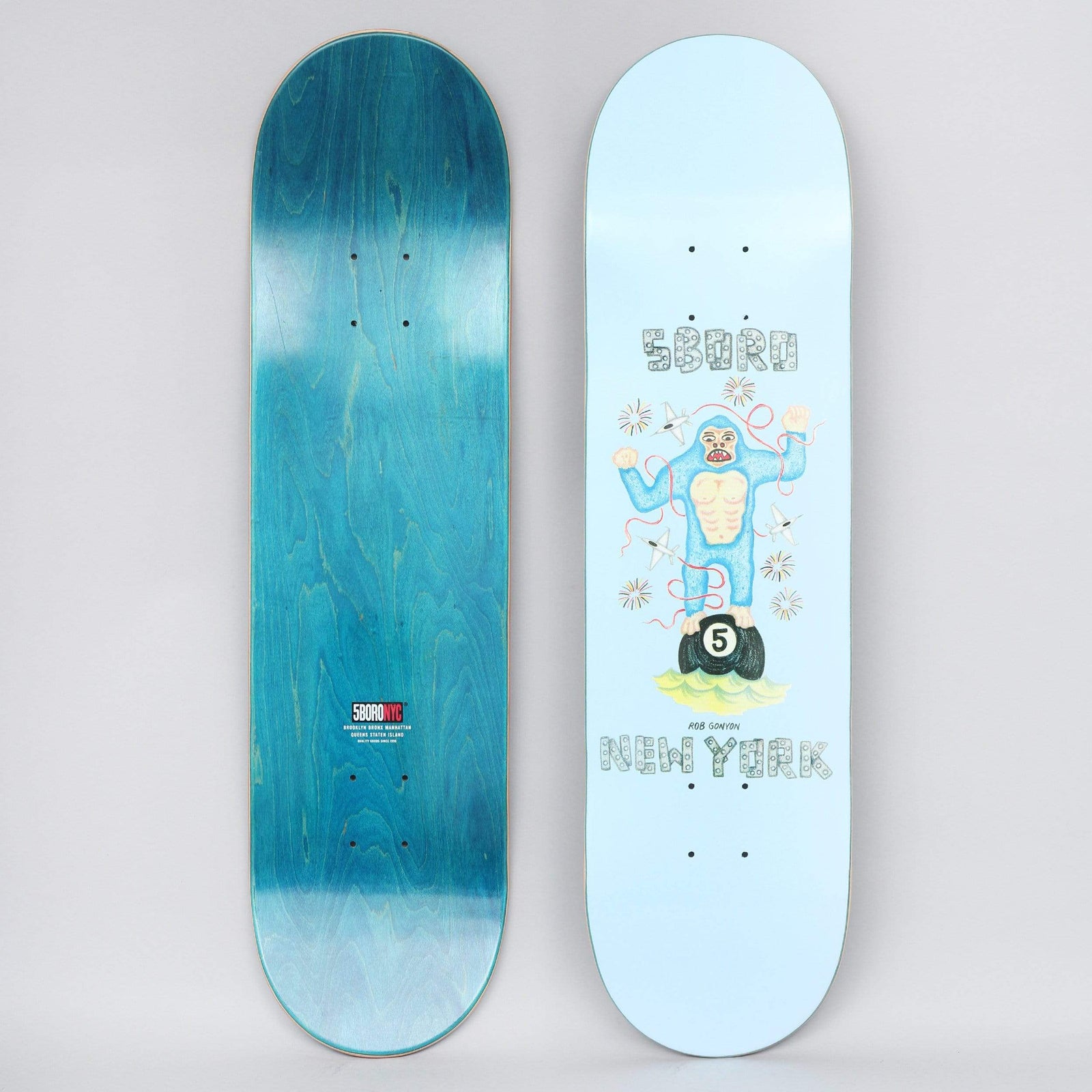 5Boro X Ds 8.25 Rob Ganyon Blue skateboard deck: Naive crayon-style drawing of a blue gorilla standing on a black number 5 pool ball, with planes and fireworks around it, between 5Boro and New York in decorated lettering on a pale blue deck. Teal underside with a red 5Boro NYC logo is also shown.