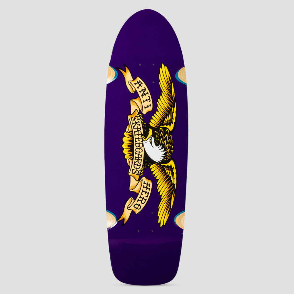 Anti Hero Shaped Eagle Caster Purple skateboard deck: Classic Anti Hero eagle with spread yellow wings and a scroll banner reading Anti Skateboards Hero, on a plain purple deck. Cream-coloured caster wheel shapes show at the edges.