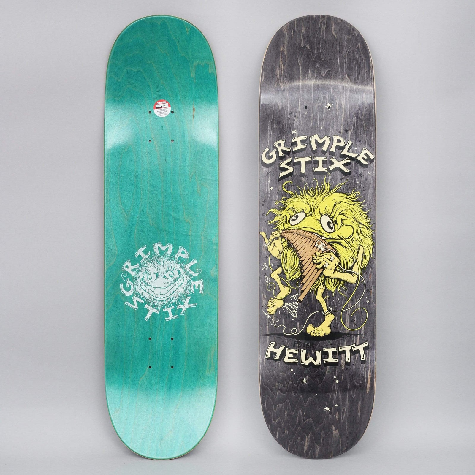 Anti Hero Grimple Hewitt Family Band skateboard deck: Hairy yellow Grimple creature with wide eyes playing a pan flute, with stars around it, on a black-stained deck. Cream lettering above and below. Teal underside with a grinning Grimple Stix logo also shown.