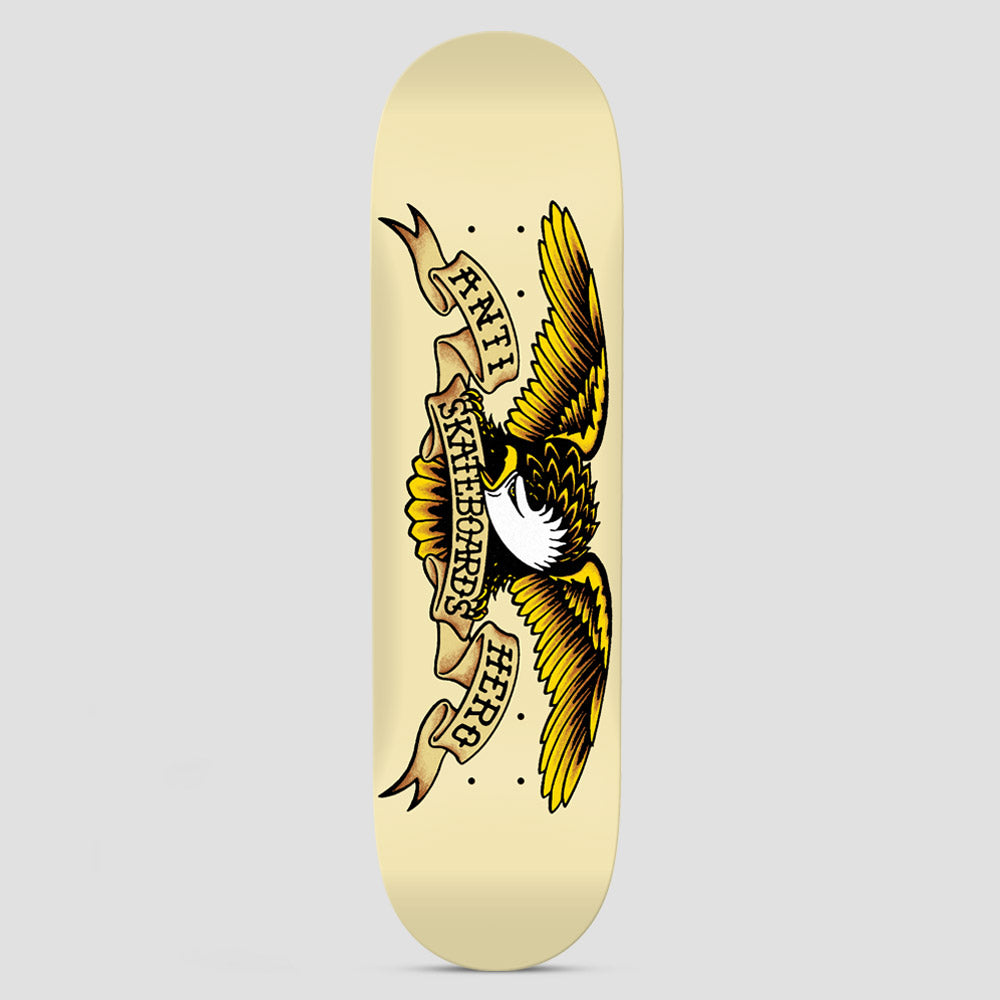 Anti Hero Classic Eagle Cream skateboard deck: A traditional tattoo-style eagle with spread yellow and brown wings and a white head, wrapped by banners reading Anti Skateboards Hero, on a cream deck.