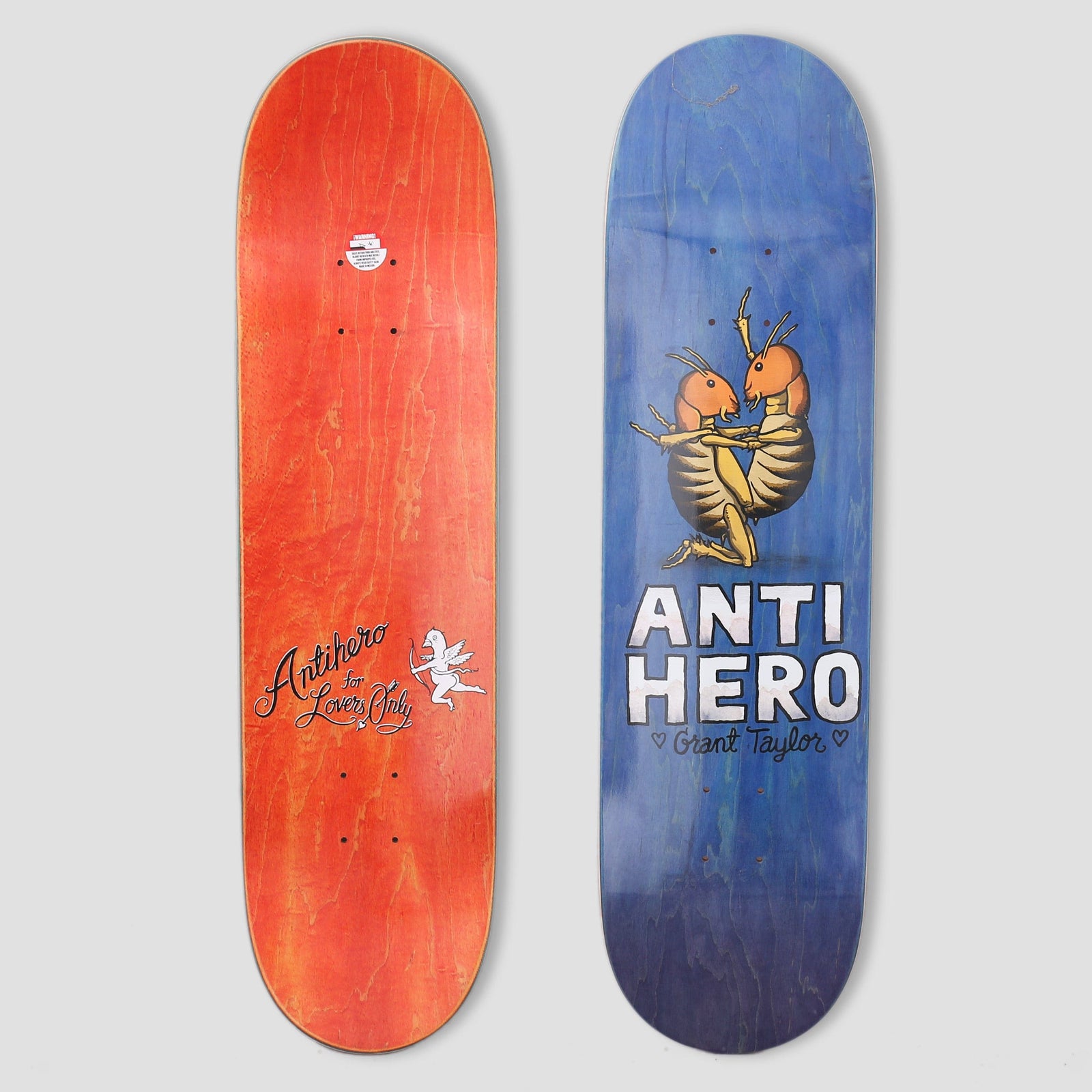 Anti Hero Taylor Lovers II Blue skateboard deck: Two orange beetles embracing, with one kneeling, above chunky white ANTI HERO lettering and the rider's name on a blue-stained deck. The orange underside has a cupid and script lettering.