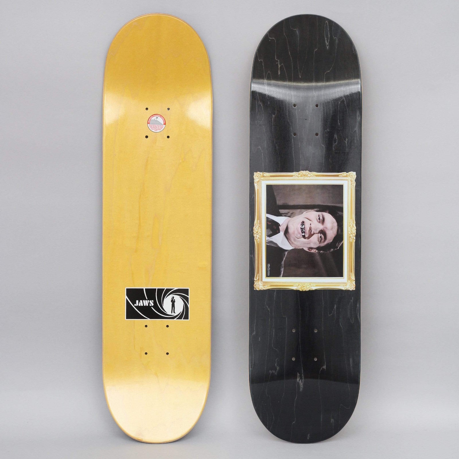 Birdhouse Jaws Golden Fried skateboard deck: Vintage black-and-white photo of a smiling man in a suit with a metal-toothed grin, inside an ornate gold frame, on a black stained deck.