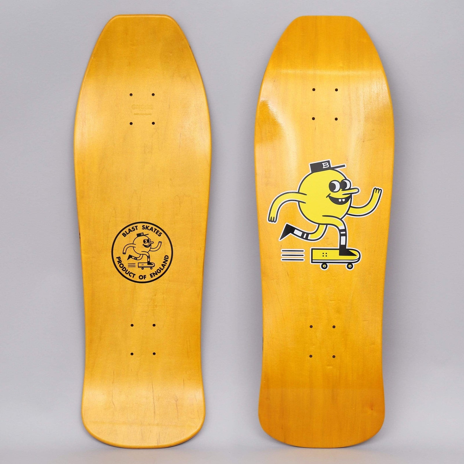 Blast Blast 10 Mascot Logo Yellow Stain skateboard deck: A cartoon yellow round-headed mascot in a cap with a B on it runs and rides a small skateboard, drawn in black outline on a yellow-stained old-school shaped deck. The underside shows a round Blast Skates Product of England stamp.