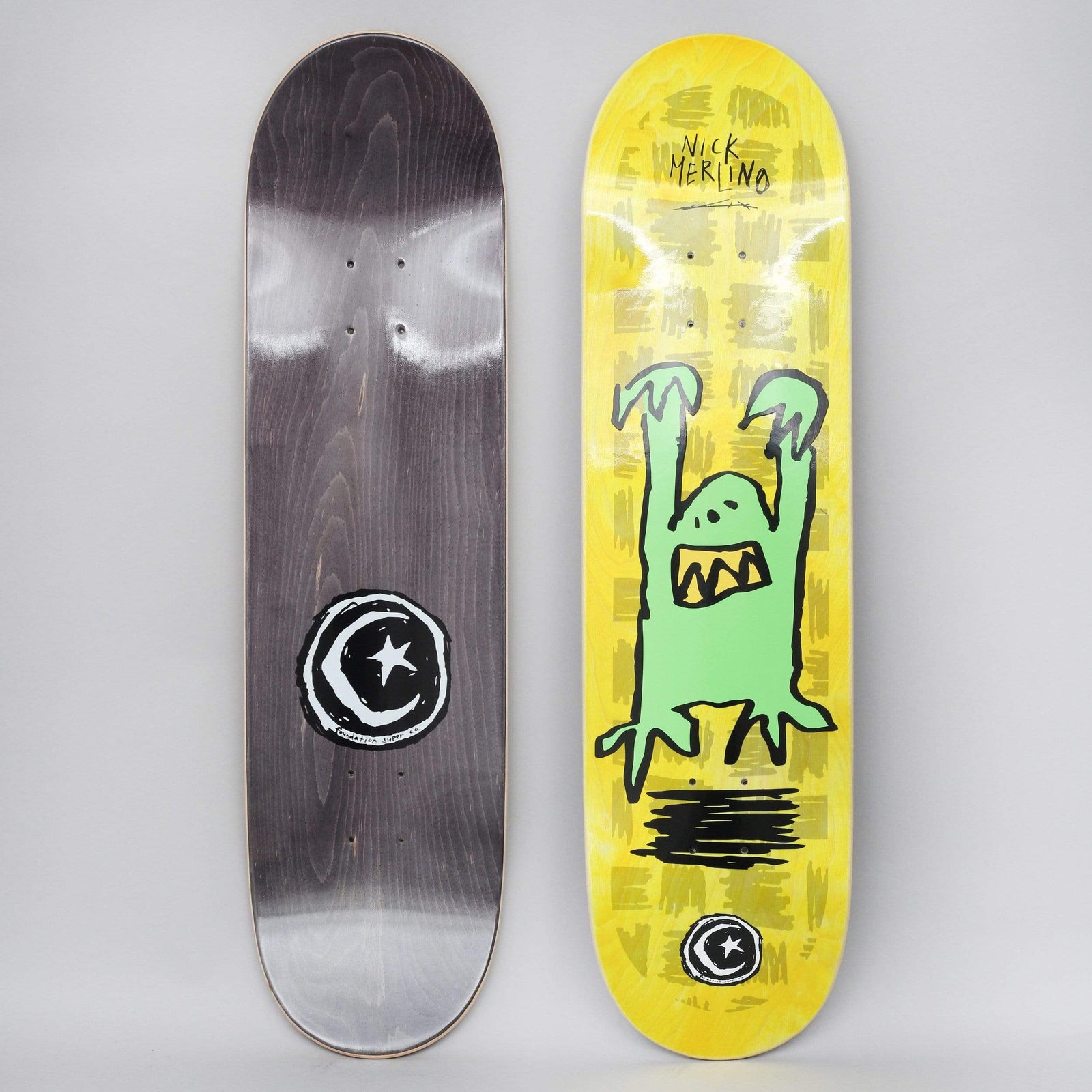 Foundation Merlino Monster Yellow skateboard deck: Crudely drawn green monster with raised claws and a jagged-toothed mouth on a yellow-stained deck with scribbled grey marks, with the Foundation star and moon logo below. Bottom view shows black stain with large logo.