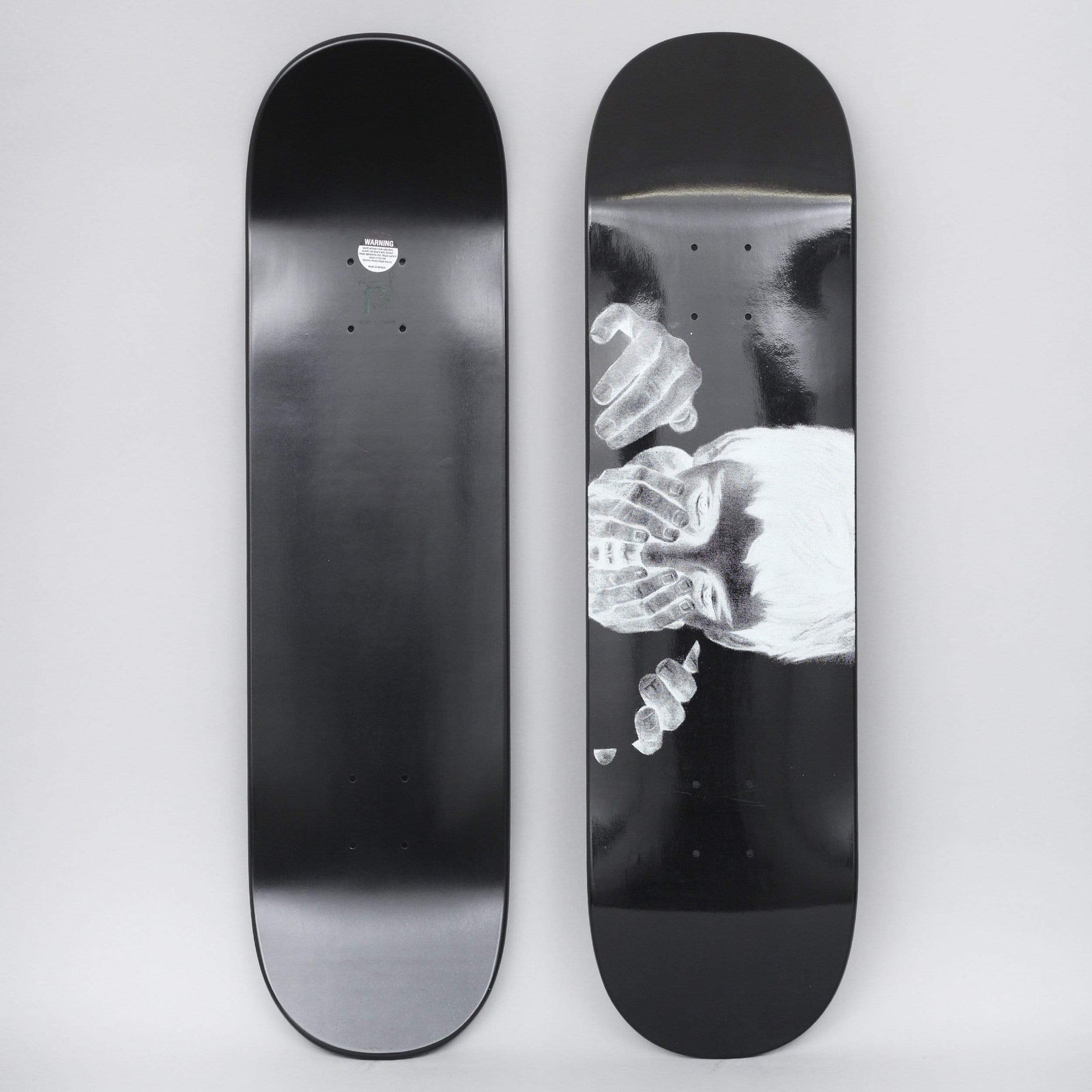 Fucking Awesome Safe Place Dipped Black skateboard deck: Black-dipped deck with a monochrome, negative-style drawing of a figure with dark hair hiding its face behind several pairs of overlapping hands, set low on the right of the board.
