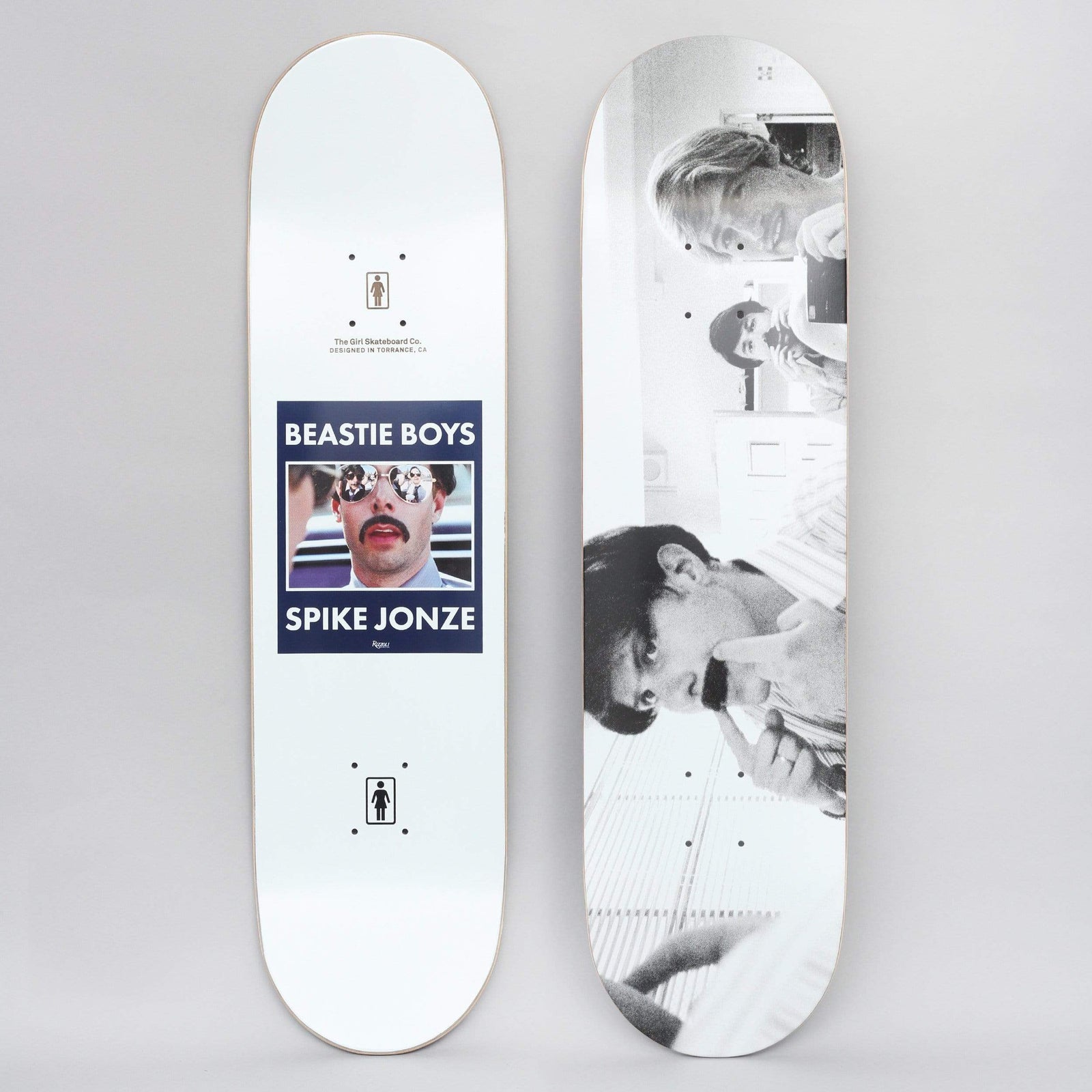 Girl Beastie Boys Spike Jonze #4 skateboard deck: Two views of a white deck. The top shows a blue-framed still of a moustached man in mirrored sunglasses with 'Beastie Boys' and 'Spike Jonze' captions; the bottom shows a black-and-white photo of three people, one with a hand to his chin.