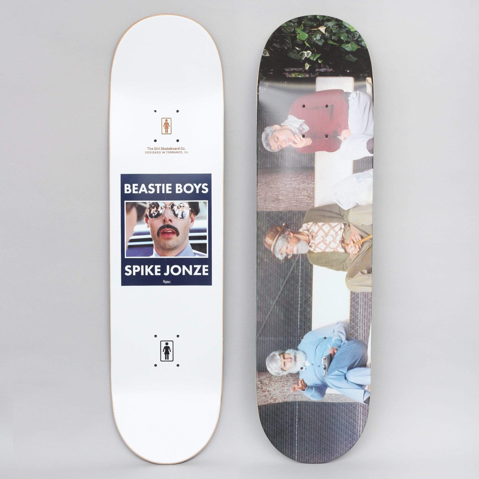 Girl Beastie Boys Spike Jonze #5 skateboard deck: Top shows a navy panel with a photo of a moustached man in mirrored sunglasses captioned Beastie Boys Spike Jonze. The underside is a photograph of three elderly figures in wigs and costume sitting on a bench.