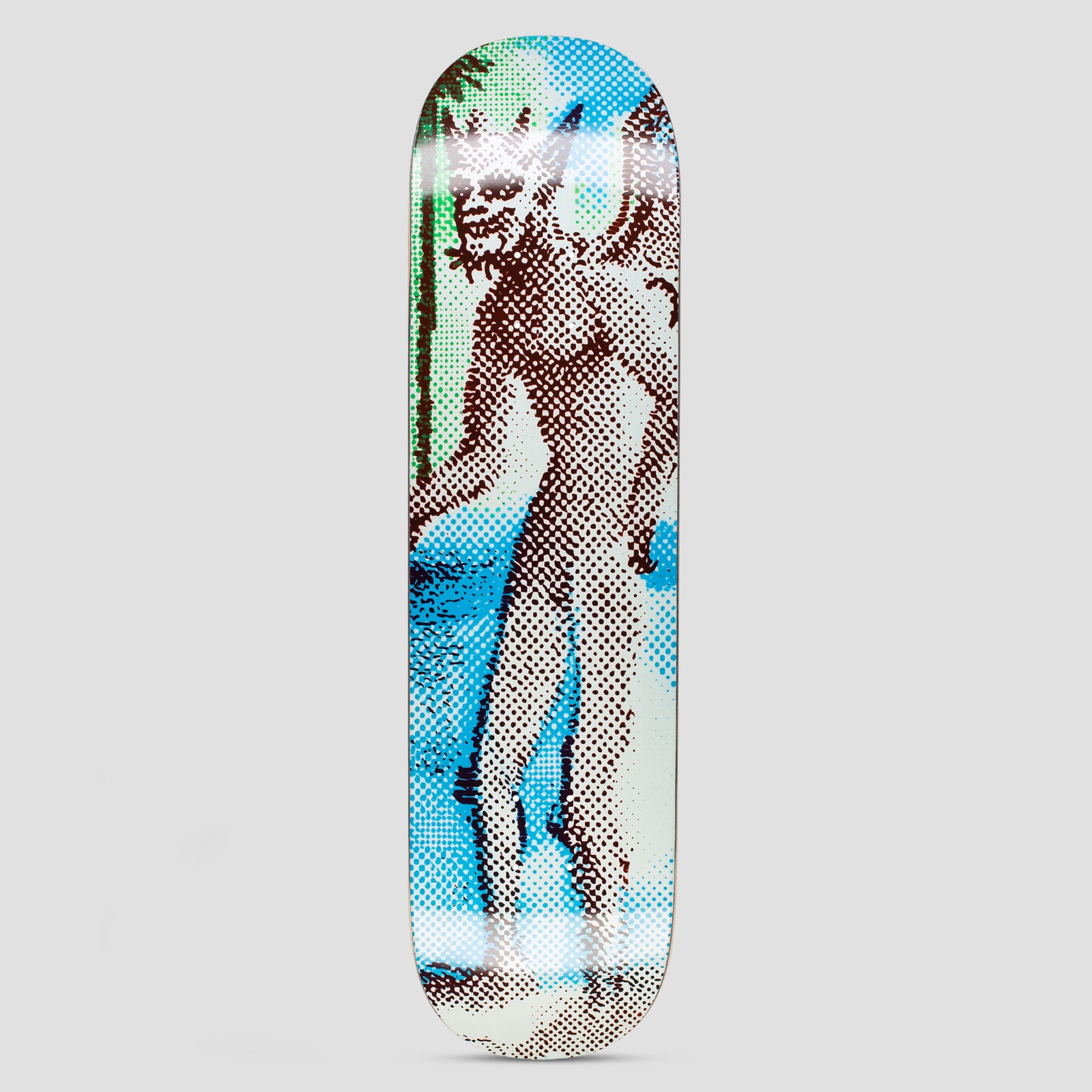 GX1000 Black Magic skateboard deck: Halftone-dot print of a bearded horned figure in a robe-like pose standing by a palm and sea, in brown, blue and green. A glossy white glare band crosses the deck.