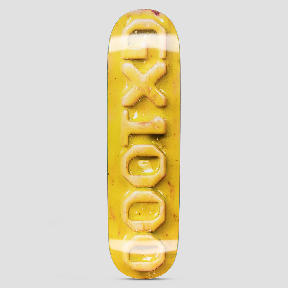 GX1000 Ceramic OG Logo Yellow skateboard deck: The GX1000 name in raised, glossy ceramic-look block letters running vertically down a mottled yellow deck, with a shiny glazed finish.