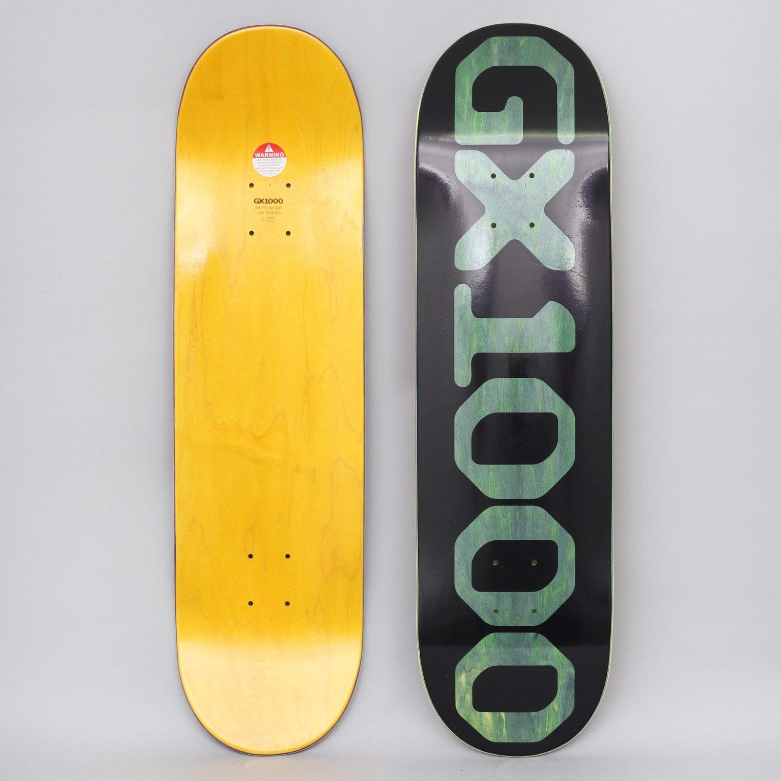 GX1000 OG Logo Olive skateboard deck: Black deck with the brand name in huge translucent olive-green capital letters and numbers running down the length of the board. Photo also shows the yellow underside.