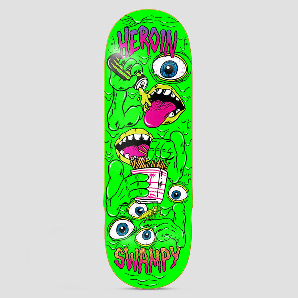 Heroin Swampy Mutate or Die skateboard deck: A wide deck covered in a slimy neon green mutant mass of eyeballs, fists and mouths, one drinking from a can and another eating chips. HEROIN is dripping in purple at the top and SWAMPY at the bottom.
