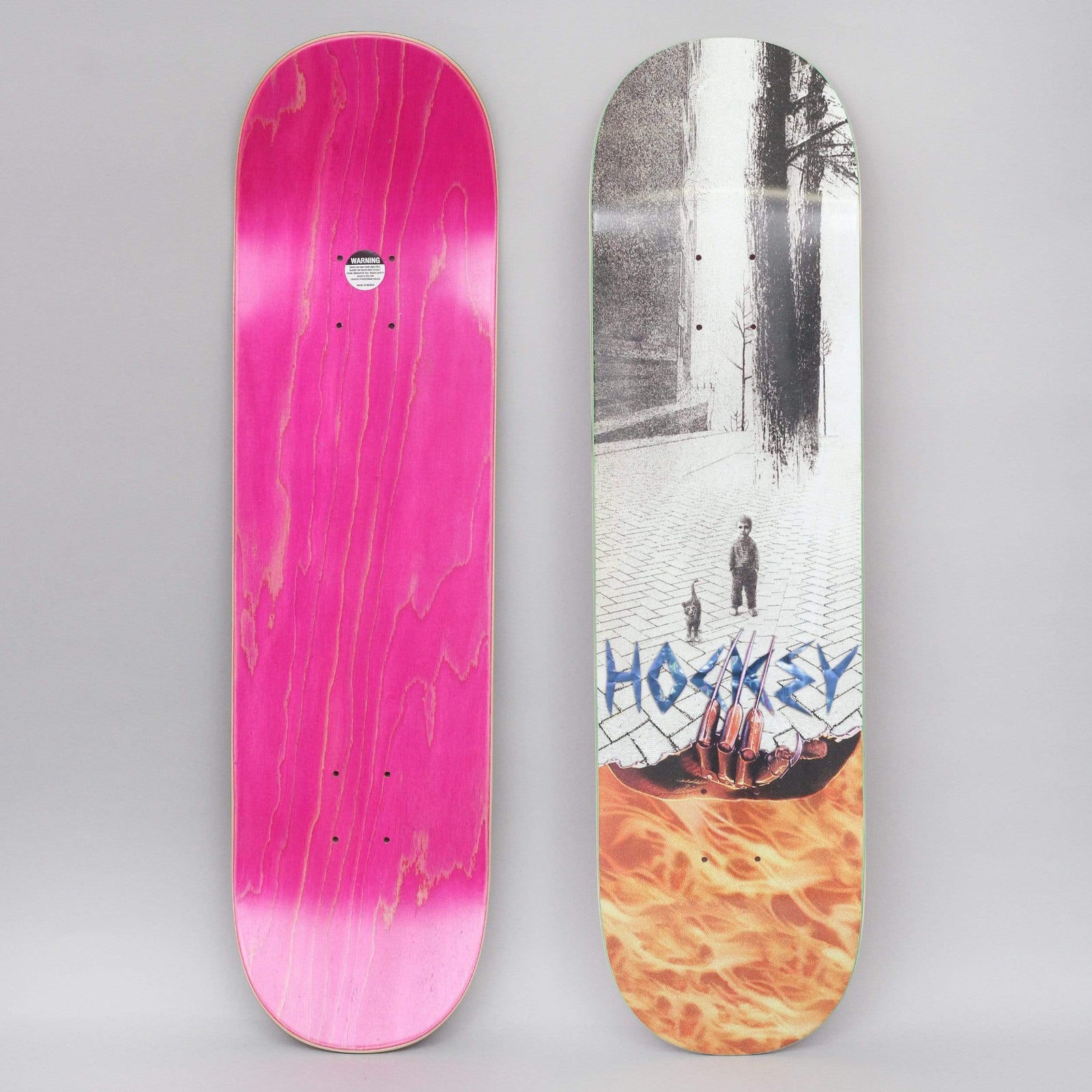 Hockey Ben Kadow Tunaboy skateboard deck: Greyscale street scene of a small child and a cat on a cobbled square with bare trees, torn open at the bottom to show a clawed skeletal hand in flames. Hockey is lettered in blue metallic style. The photo also shows the pink underside.