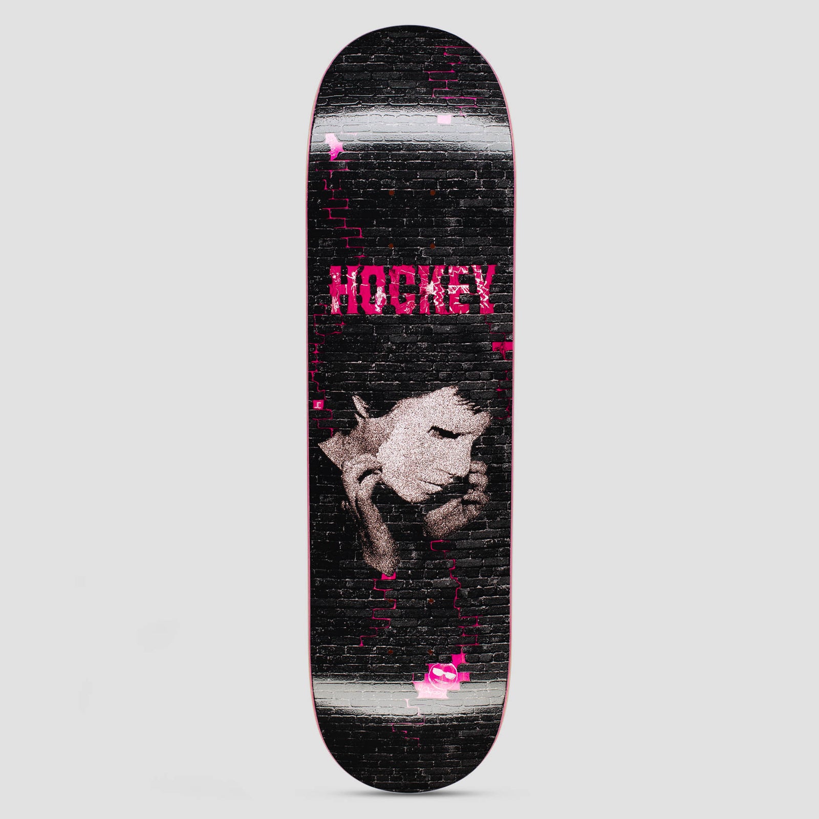 Hockey Joe Debut Shape 1 skateboard deck: A grainy pink-toned portrait of a person with eyes closed, hands against their face, on a black brick wall with pink bricks and glowing highlights. The Hockey name is in pink at the top.