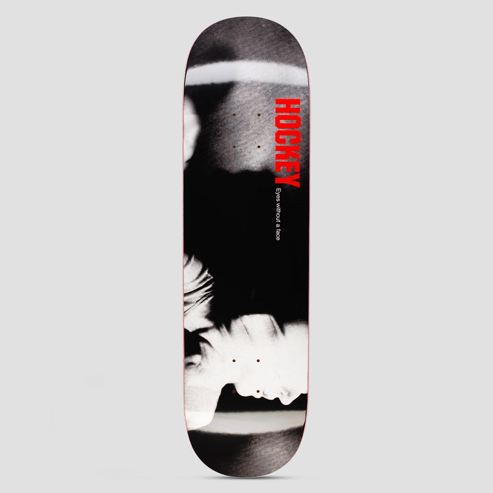Hockey Shadowbox John Fitzgerald Shape 1 skateboard deck: A high-contrast black and white photograph of a pale, blurred figure's face and shoulders against black, with the red brand name set vertically and a small film title beside it.