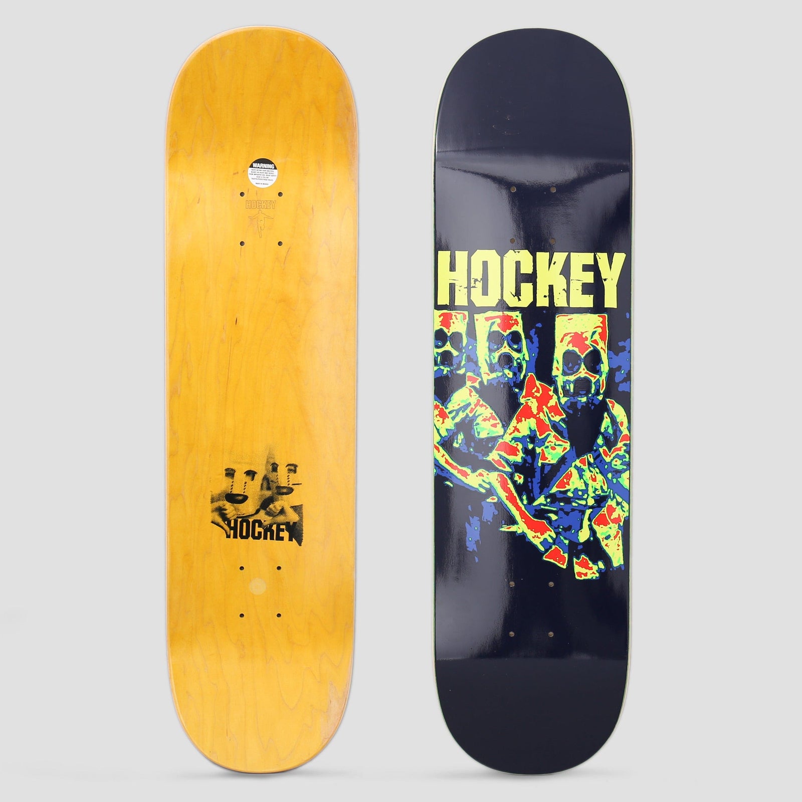 Hockey Bag Heads 3 Navy skateboard deck: Three figures with paper bags over their heads, in a posterised, heat-map style print of red, yellow, green and blue, below yellow 'HOCKEY' lettering, on a navy deck. Yellow underside with a small print also shown.