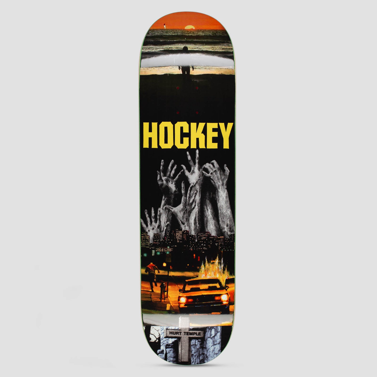 Hockey Andrew Allen Hurt Temple Shape 1 skateboard deck: Photo-collage scene: a sunset over the sea at the top, grey hands reaching up from a night city skyline, a burning car and a running figure on a street, and a cross at the tail. Yellow HOCKEY lettering across the middle.