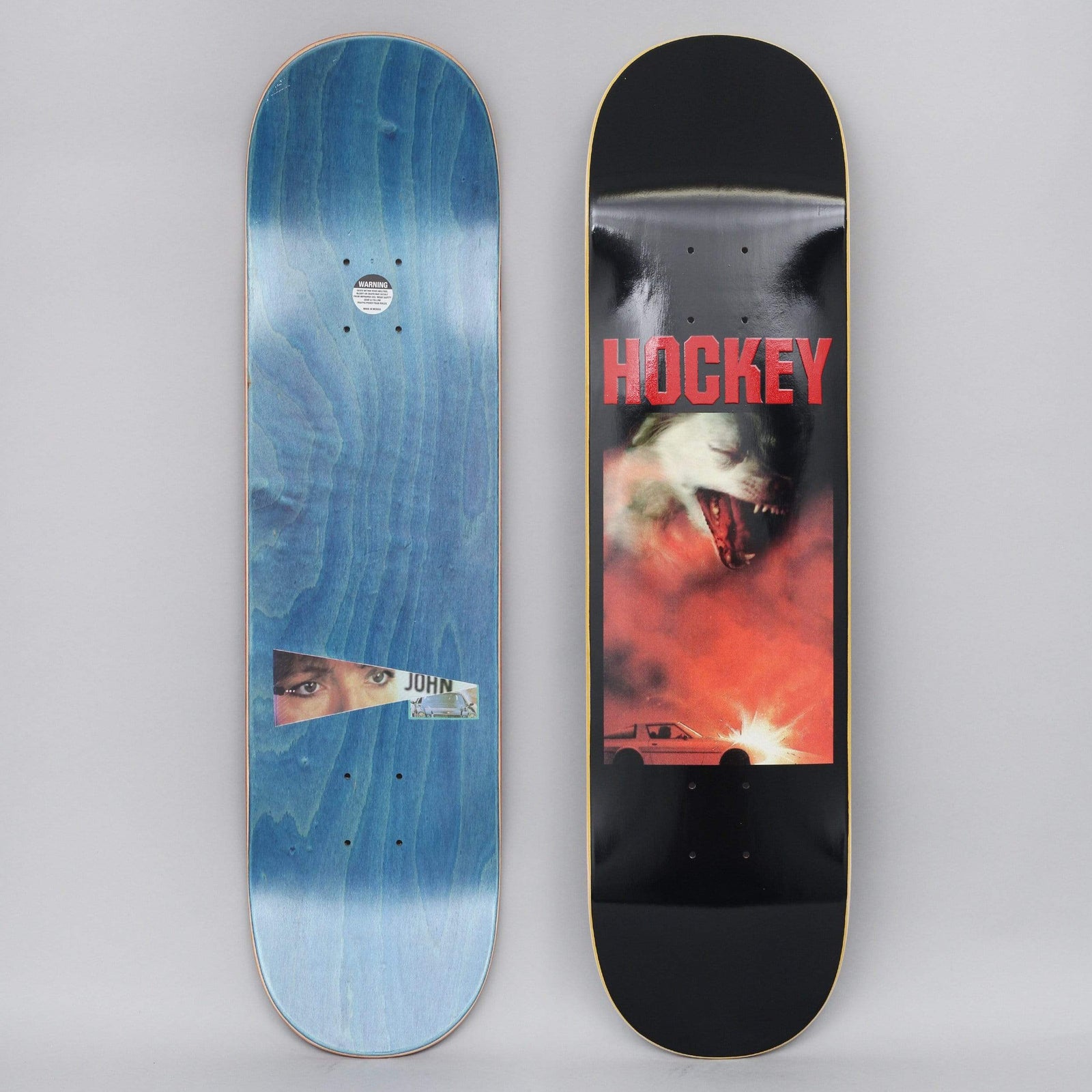 Hockey John Fitzgerald Corvette Black skateboard deck: Red-toned photographic image of a snarling white wolf or dog above a white sports car with a bright flash, beneath a red Hockey logo, on a black deck. The underside has a cut-out eye photo labelled John.