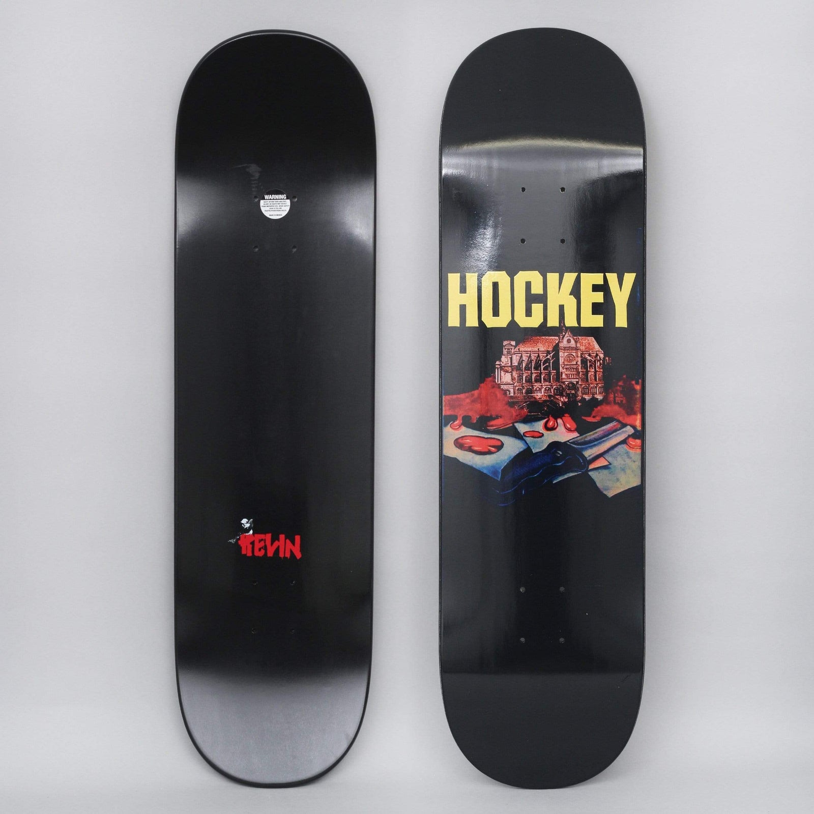 Hockey Kevin Rodriguez St. Kev Black skateboard deck: Painted scene of an ornate gothic building above blood-red splashes and an open book or papers with a dark hand, on a black deck under a large yellow Hockey logo. A small red Kevin signature appears on the underside.