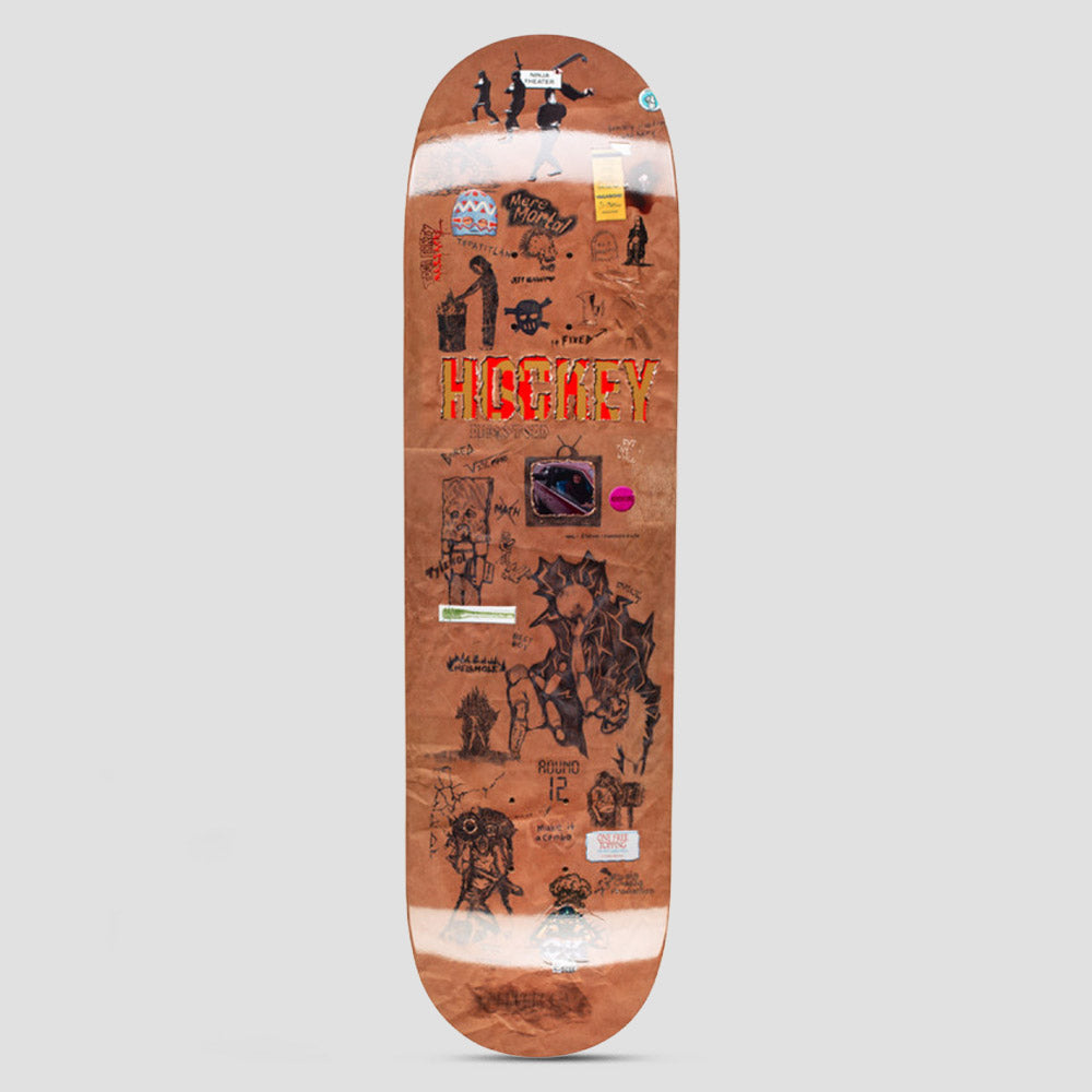 Hockey Paper Cover Diego Todd Board Shape 2 skateboard deck: A brown paper-bag textured deck covered in small collaged scribbles, stickers, tiny drawings and notes, with a red and gold Hockey logo across the middle and a small framed picture of a planet below it.