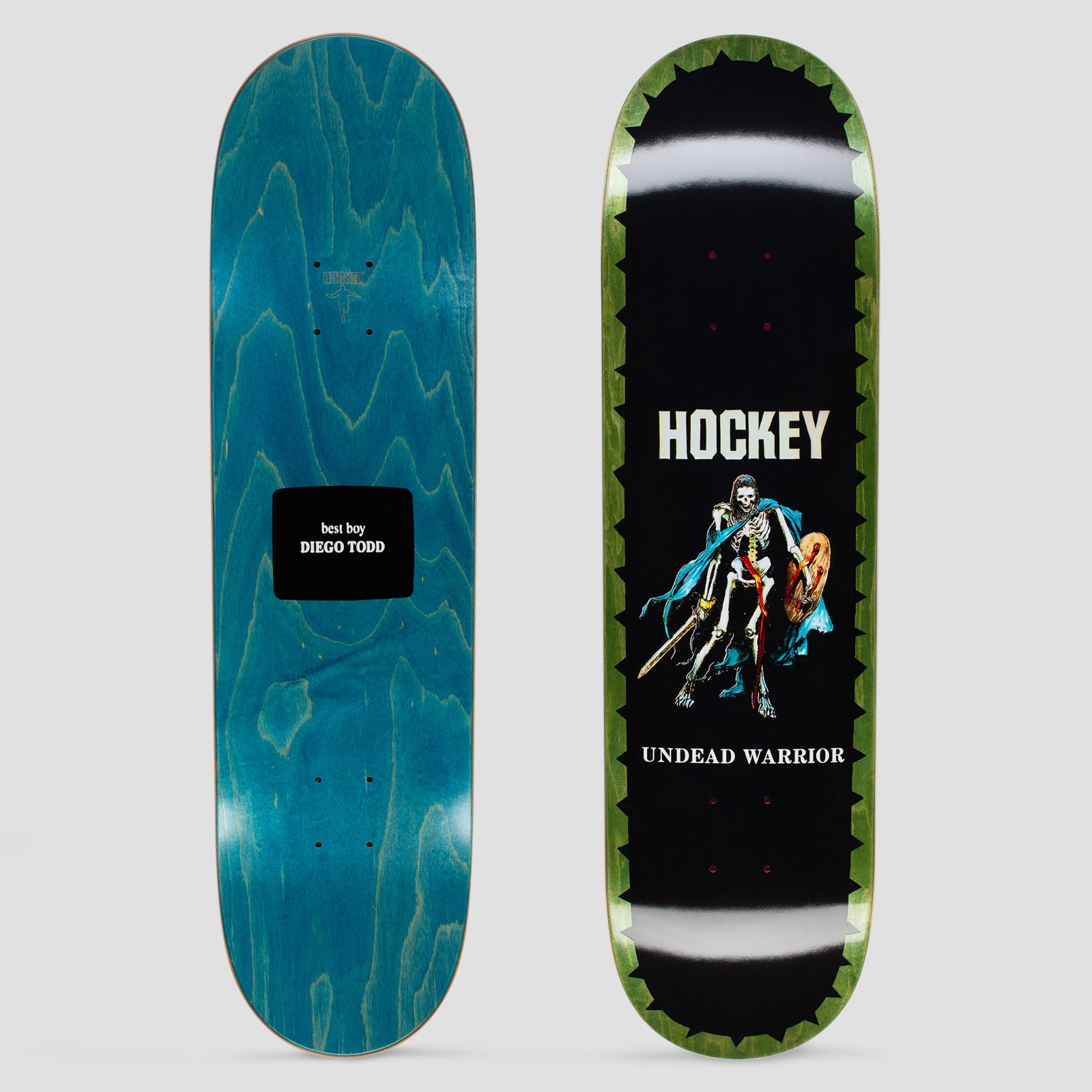 Hockey Diego Todd Undead Warrior skateboard deck: Skeleton warrior with sword, round shield and a blue cape on a black deck, edged with a green jagged border; brand name above and title below. The other deck is blue stain with a black label.